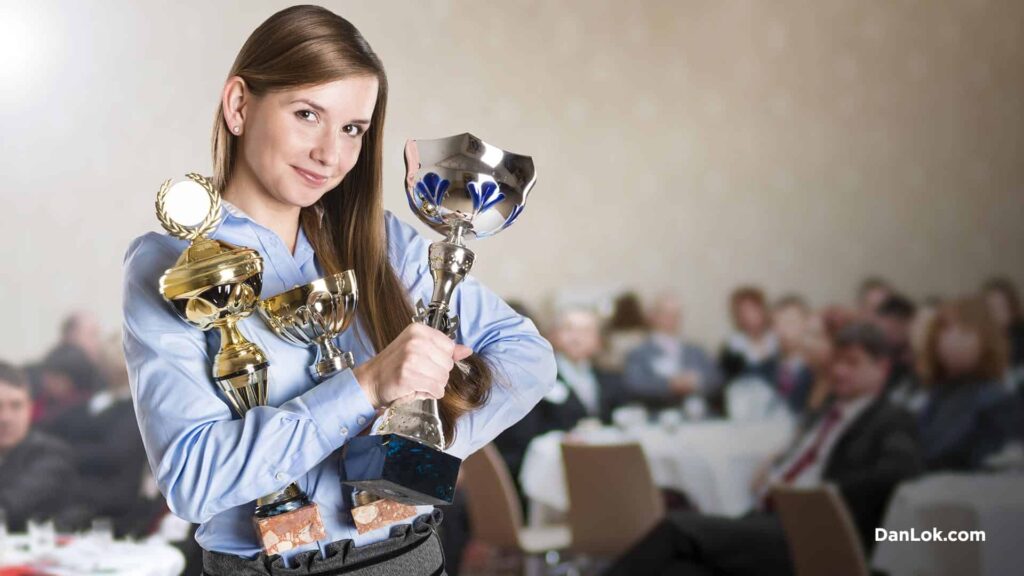 Business woman holding trophies and awards