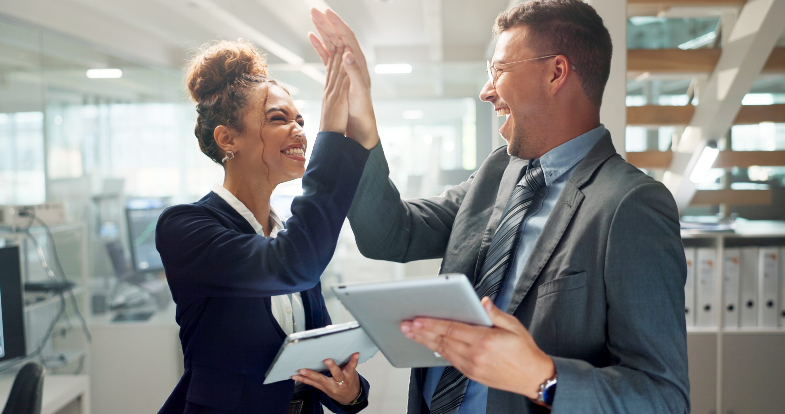 2 people are high five for their success on improving market strategies