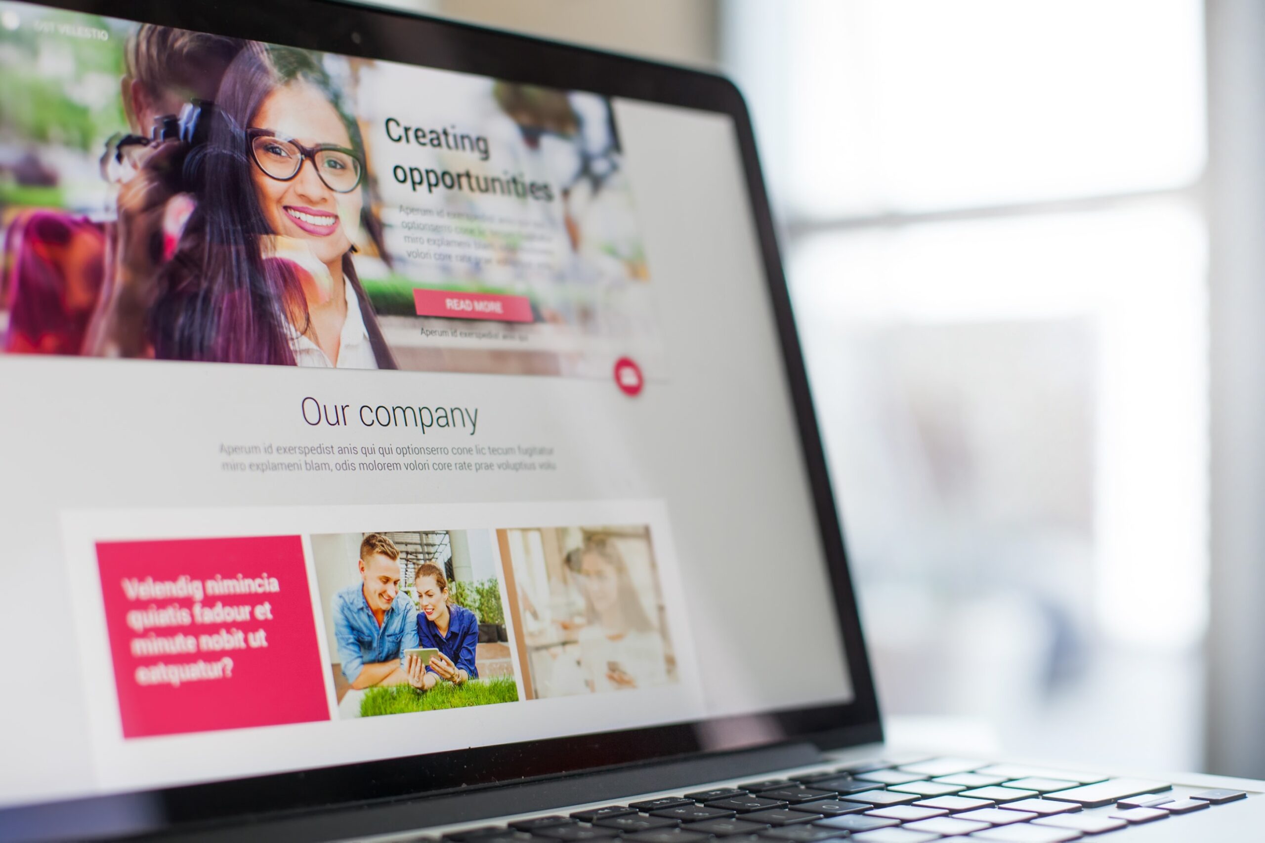 Laptop screen displaying a modern business landing page with clean layout, lead capture section, and call-to-action button, viewed in a bright professional workspace.