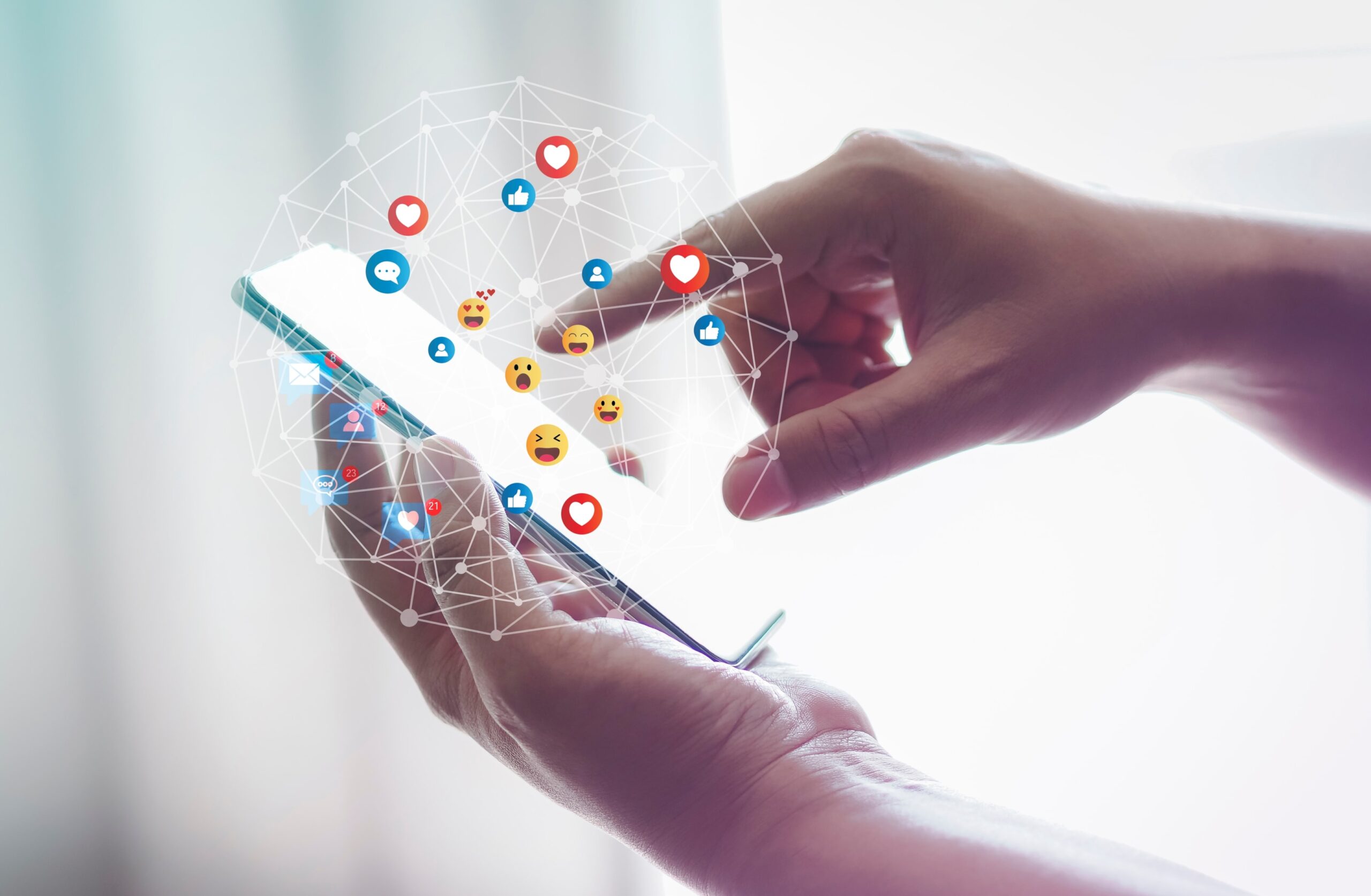 Close-up of hands using a smartphone with floating social media icons, symbolizing user engagement and online sharing